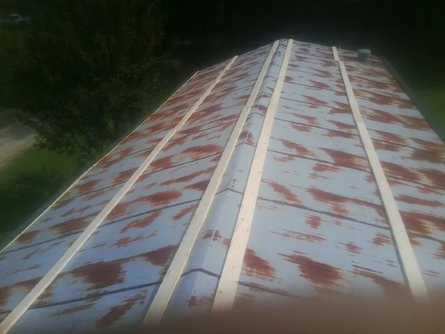 Rusted metal roof panels with new wood purlins before replacement — Storm Damage Roof Repair in Ulmer by Roofing Brothers