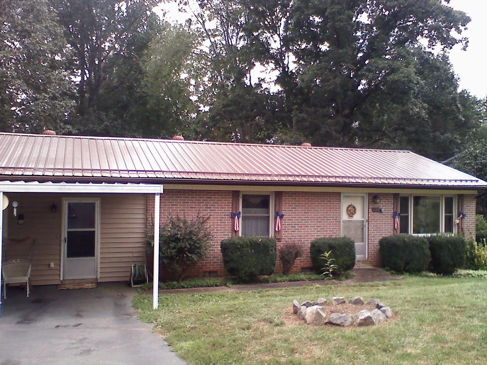 Bronze metal roof and carport on a brick ranch home — Roof Repair work by our crew in Ulmer